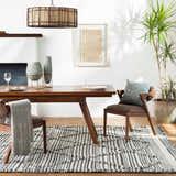 Dining room scene with a wood table and the black and ivory striped Nairobi Area Rug. Roomscene-Rectangle