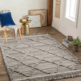 Living room scene with a black, gray, and ivory Nairobi Area Rug, chair, and gold accent table. Roomscene-Rectangle