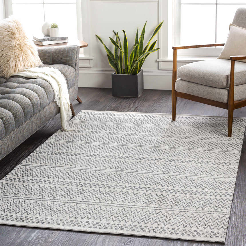 Living room scene with a gray sofa and Nalcrest Washable Area Rug in charcoal and white with a geometric pattern. Roomscene-Rectangle