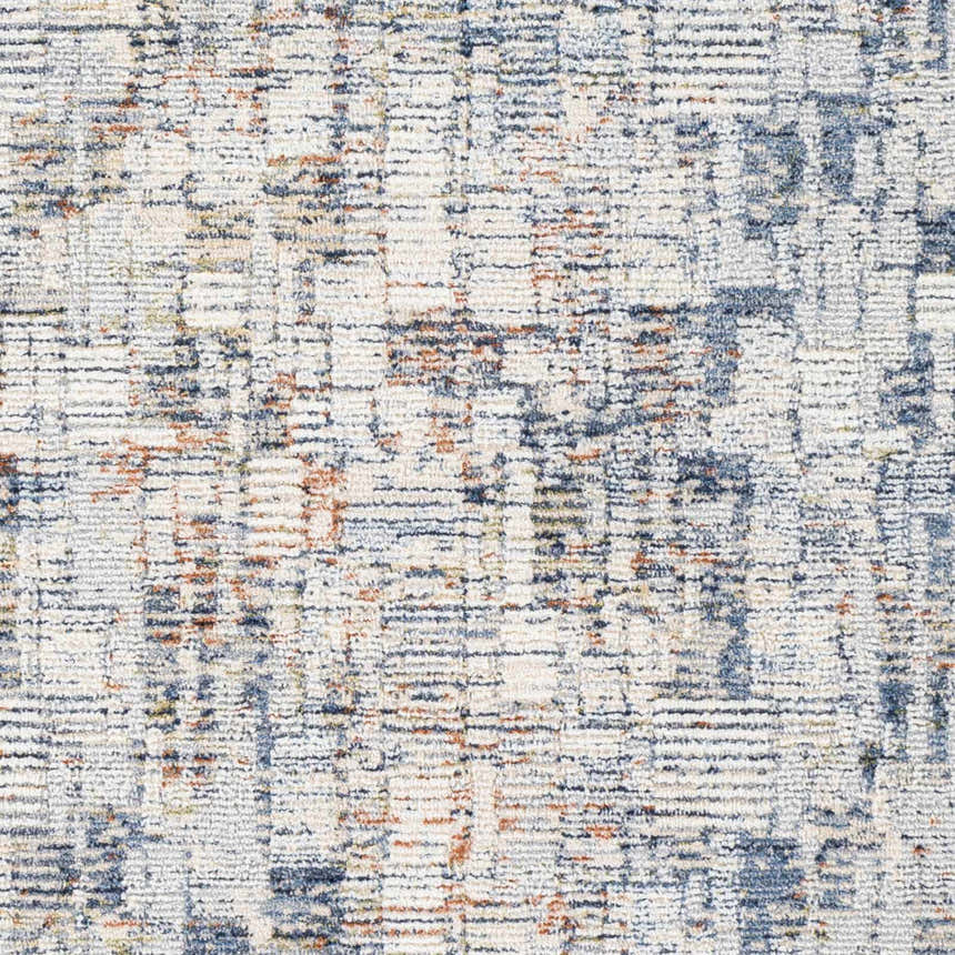 Close-up of Nalus Area Rug showing a cream base with brick red, denim, and gray abstract pattern. Swatch