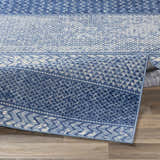 Close-up of the Nampa Area Rug showing its denim, ivory, and navy contemporary pattern and machine-woven texture. Fold