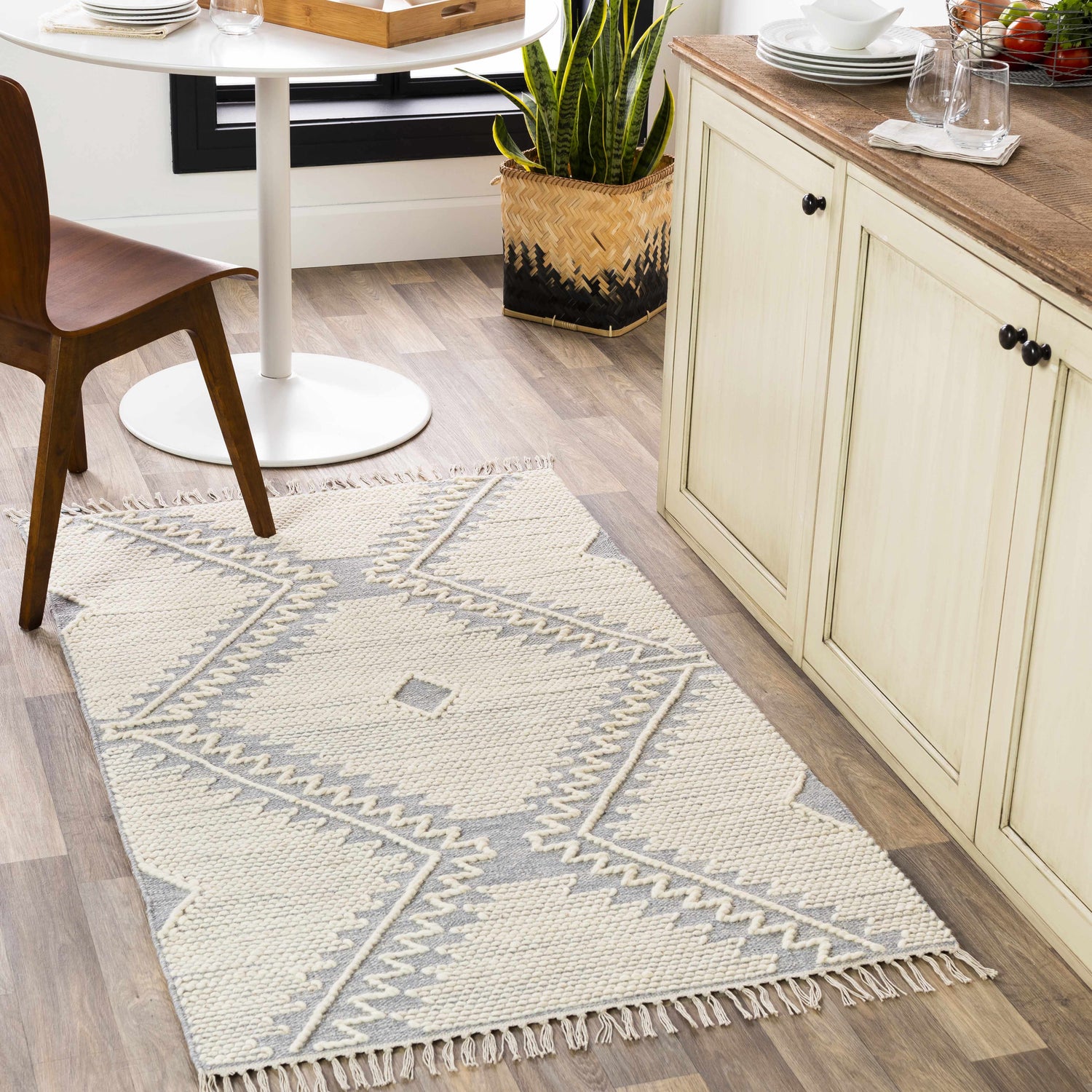 Kitchen scene with Naranjito Cream/Slate Trellis rug, cream cabinets, round table, and wood floors. Roomscene-Rectangle