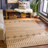 Living room scene with tan Nasugbu Jute Carpet. Bohemian rug with geometric pattern, tan sofa, and wood bench. Roomscene-Rectangle