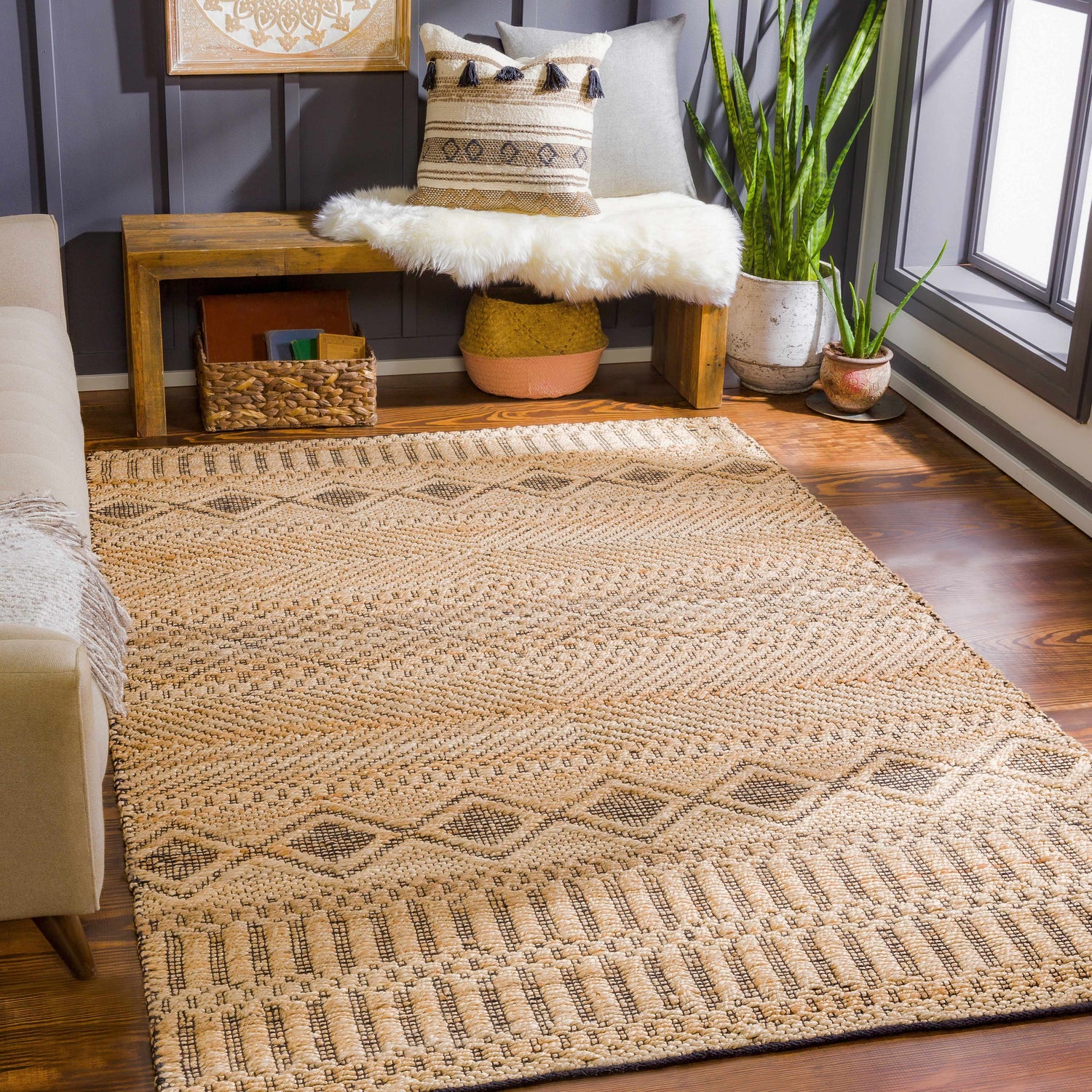 Living room scene with tan Nasugbu Jute Carpet. Bohemian rug with geometric pattern, tan sofa, and wood bench. Roomscene-Rectangle