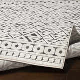 Close-up of Naylor Beige/Charcoal Rug. Farmhouse style rug with geometric diamond and circle pattern. Machine woven texture. Fold