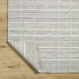 Close-up of the hand woven Nissa Checkered Area Rug. Light gray wool rug with off white checkered pattern. Fold
