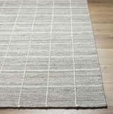 Close-up of the hand-woven Nissa Checkered Area Rug. Light gray wool rug with an off-white checkered pattern. Front