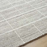 Close-up of the hand-woven Nissa Checkered Area Rug. Light gray and off-white wool rug with a traditional checkered pattern. Texture