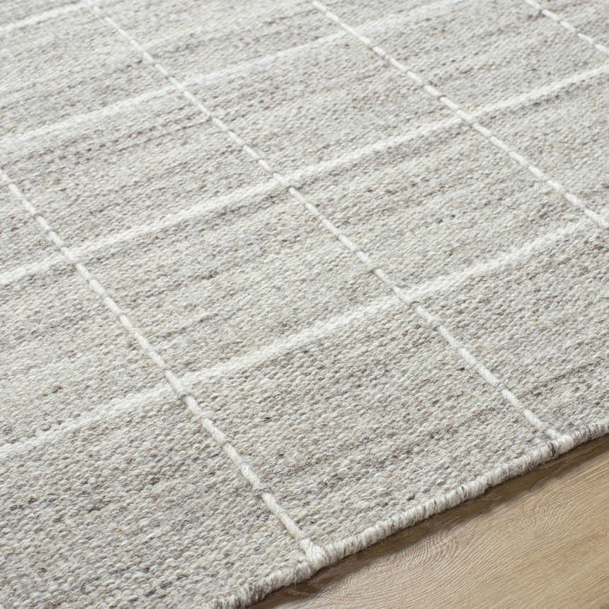 Close-up of the hand-woven Nissa Checkered Area Rug. Light gray and off-white wool rug with a traditional checkered pattern. Texture