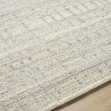 Close-up of the hand woven Nissa Tan Area Rug showing the ivory and tan wool texture and subtle pattern. Texture
