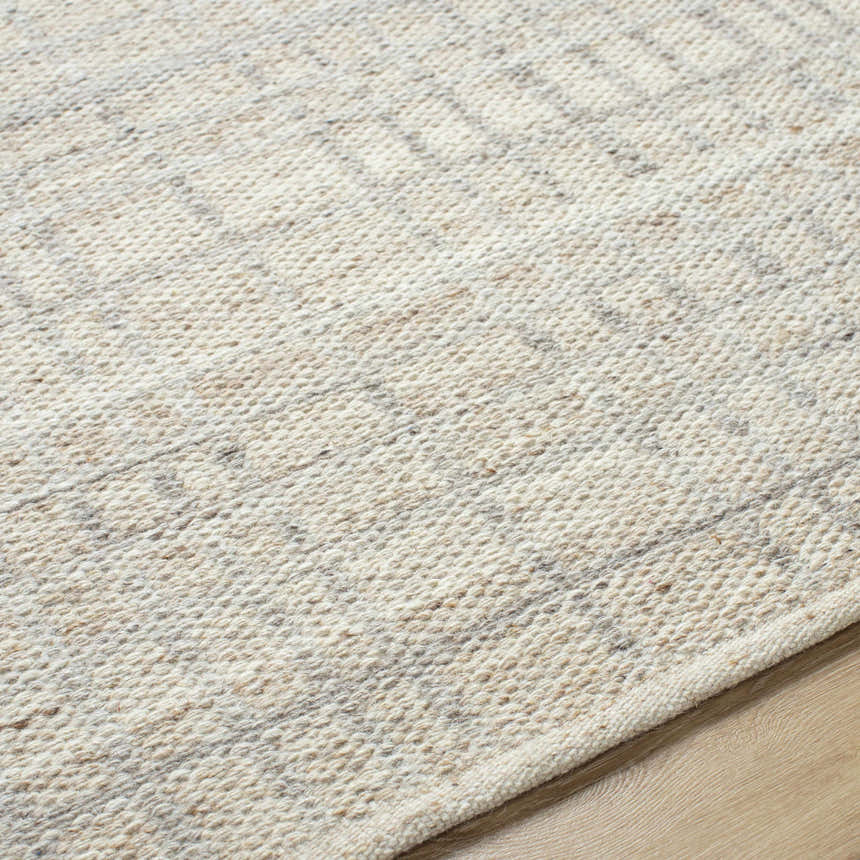 Close-up of the hand woven Nissa Tan Area Rug showing the ivory and tan wool texture and subtle pattern. Texture