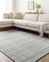 Living room scene with a light beige sectional sofa and the Nissa Blue Gray Checkered Area Rug on hardwood floors. Roomscene-Rectangle