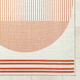 Close up of the Nabil Cream Area Rug featuring an orange striped pattern and cream background. Corner