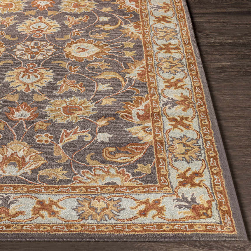 Close-up of the hand-tufted Cherryfield 1004 rug. Oriental floral pattern in beige, burnt orange, and slate on a dark wood floor. Front