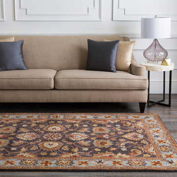 Living room scene with a beige sofa and the Cherryfield 1004 wool rug in beige, burnt orange, and slate blue tones. Roomscene-Rectangle
