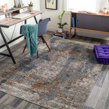 Home office with Andreas Luxe Fringe Rug in brick red, dark blue, and gray. Desk, chair, and purple cushion create a cozy workspace. Roomscene-Rectangle