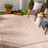 Outdoor patio scene with Noam Tan Indoor & Outdoor Rug, wooden chairs, white side table, and potted plants. Roomscene-Rectangle