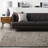 Living room scene with a Sage Brown Elsu Area Rug, gray sofa, and mid-century modern side table. Roomscene-Rectangle