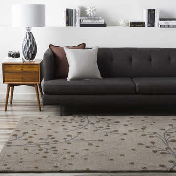 Living room scene with a Sage Brown Elsu Area Rug, gray sofa, and mid-century modern side table. Roomscene-Rectangle