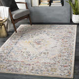Living room scene with a Newkirk Area Rug in cream, brick red, and blue, styled with a mid-century chair and gold side table. Roomscene-Rectangle