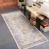 Entryway with a Newkirk Area Rug runner, woven bench, plants, and gray wood floors. Roomscene-Runner