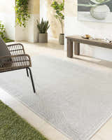 Styled patio with Nuela Light Gray Area Rug, woven chair, wood bench, and potted plants. Farmhouse style. Roomscene-Rectangle