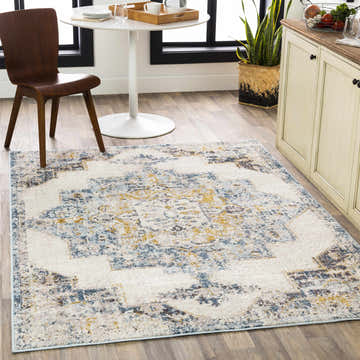 Bright kitchen scene with a Nibley Area Rug in blue, brown, and mustard tones under a white table and wooden chair. Roomscene-Rectangle