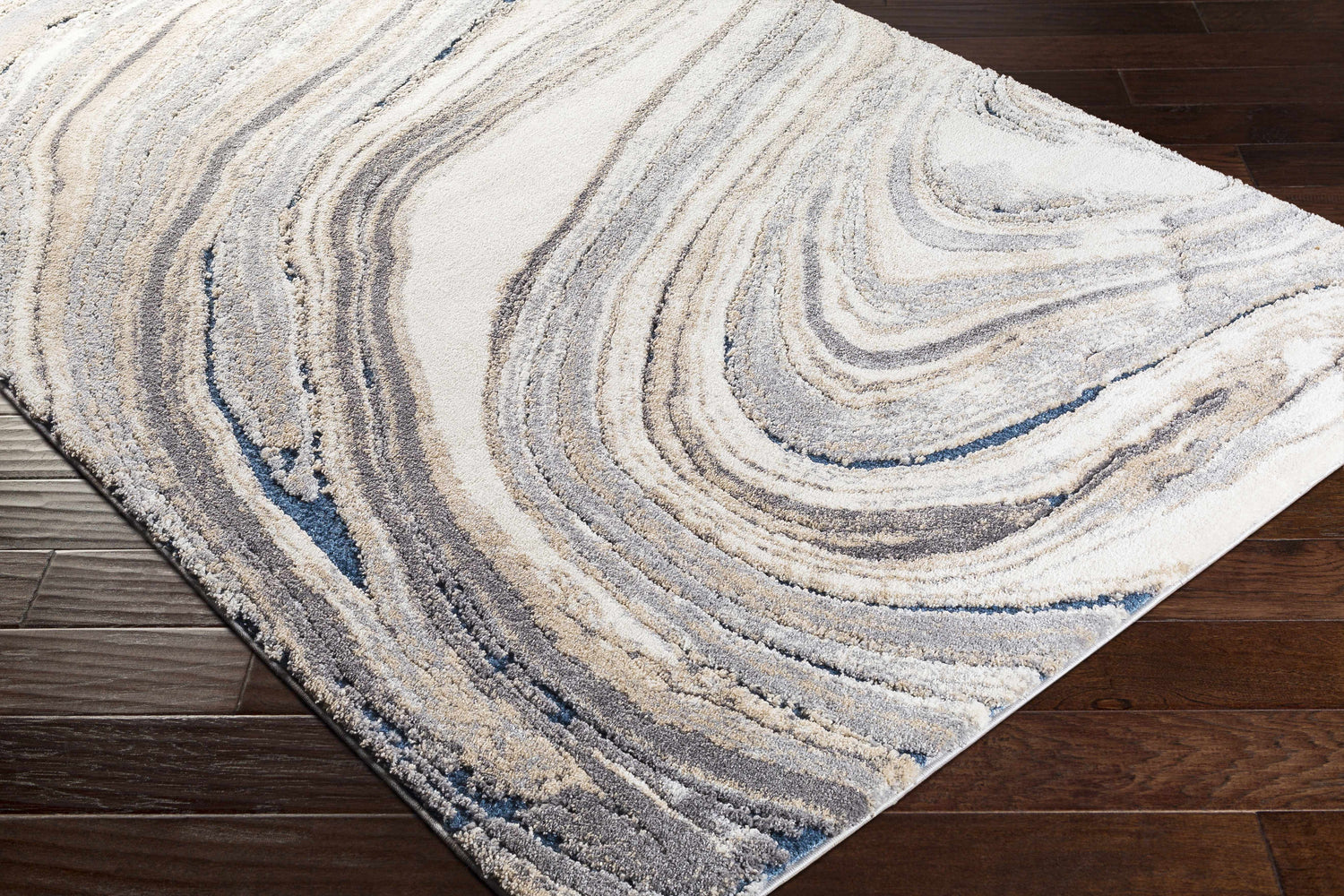 Close-up of the Nillumbik Gray Marble Design Rug featuring a swirling pattern in charcoal, gray, ivory, and blue. Corner