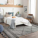 Bedroom scene with a black and cream Ninderry Wool Area Rug, white bed, gray nightstands, and wood accents. Roomscene-Rectangle