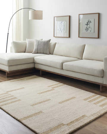 Living room scene with a beige Nadav Area Rug, sectional sofa, and minimalist art. Roomscene-Rectangle