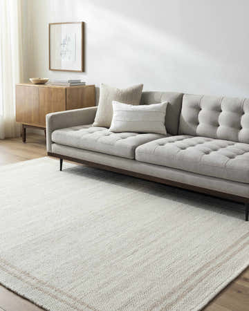 Living room with a gray sofa and the ivory and tan Nimue Area Rug. Roomscene-Rectangle