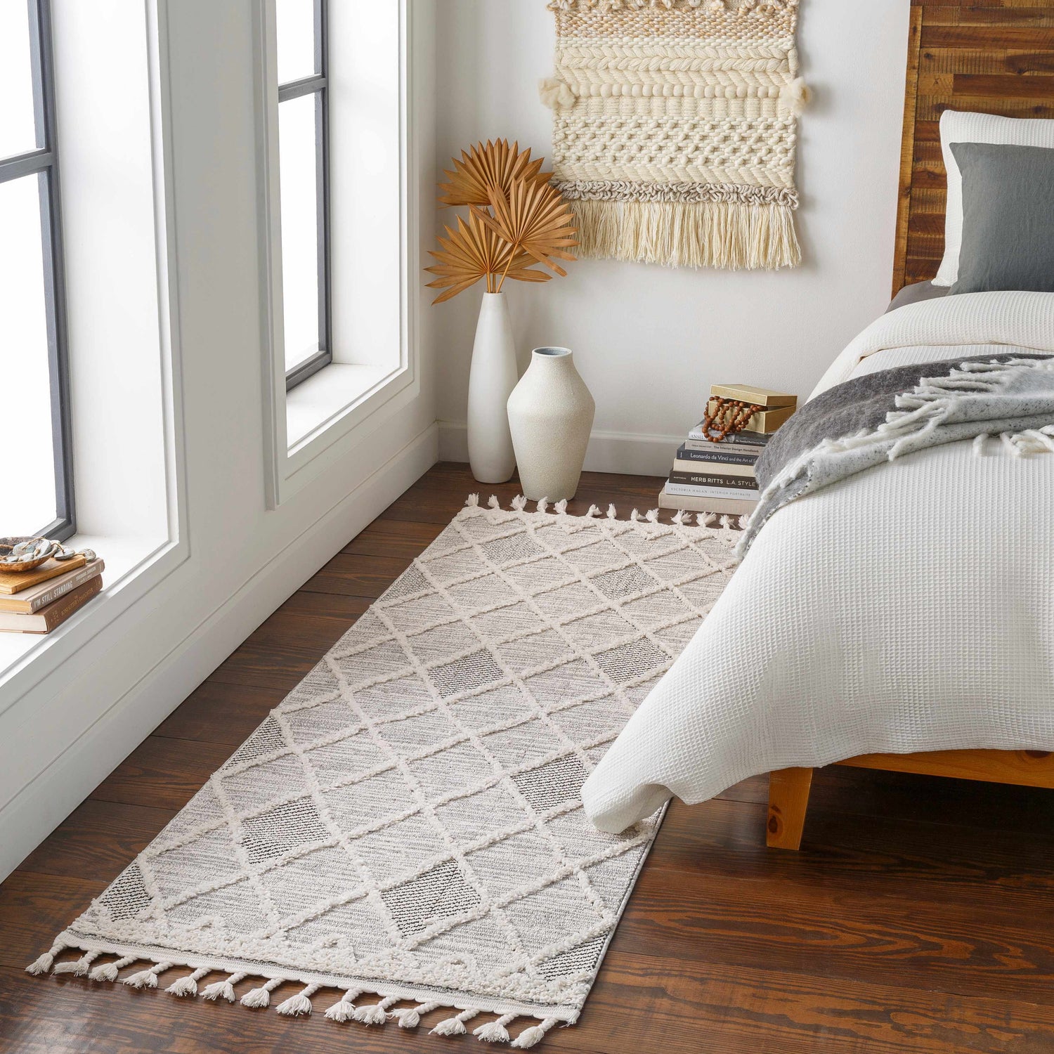 Bedroom scene with a gray and ivory Norvelt High/Low Pile Rug with Tassels, wood floors, and neutral decor. Roomscene-Runner
