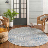 Coastal porch with wicker chairs and a round Novato All Over Pattern Performance Rug in blue and taupe. Roomscene-Round