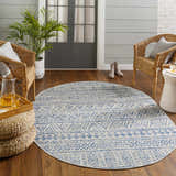 Sunroom with wicker chairs and round Novato All Over Pattern Performance Rug in blue and taupe. Roomscene-Round