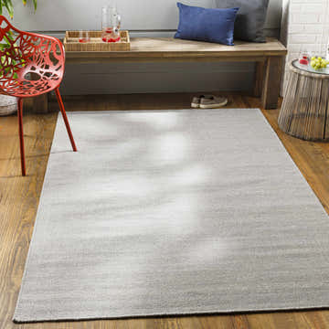 Light gray Northop Indoor Outdoor Rug in a mudroom with a wooden bench and red chair. Roomscene-Rectangle
