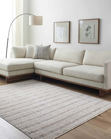 Living room with a neutral sofa and the Nuhad area rug in dark red, gray, navy, rust, and white. Roomscene-Rectangle
