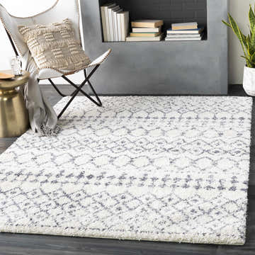 Living room scene with a white butterfly chair and the White Gray Navassa Rug. Roomscene-Rectangle