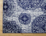 Close-up of the Nubia Area Rug, showcasing its navy and pale blue farmhouse-style floral medallion pattern. Corner