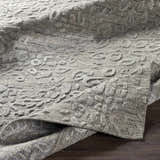 Close-up of the Newburn Area Carpet. Charcoal and gray tones with a subtle, raised pattern and hand-loomed texture. Front