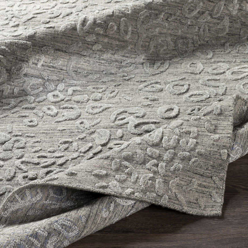 Close-up of the Newburn Area Carpet. Charcoal and gray tones with a subtle, raised pattern and hand-loomed texture. Front