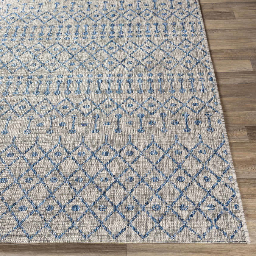 Close up of the Newbern Outdoor Rug showing its blue geometric pattern and woven texture. Front
