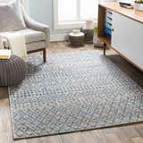 Living room scene with blue and taupe Newbern Outdoor Rug, gray chair, and modern cabinet. Roomscene-Rectangle