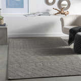 Living room scene with charcoal Newtonhill Clearance Rug, neutral chair, and modern decor. Roomscene-Rectangle