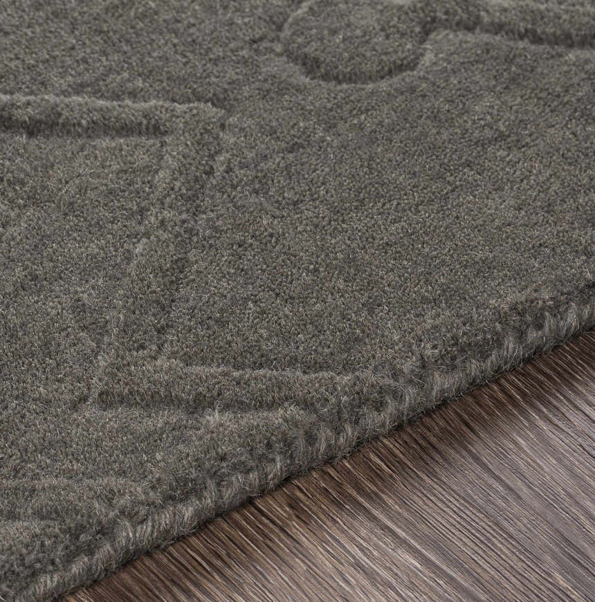 Close-up of the charcoal Newtonhill Clearance Rug, a hand-loomed wool rug with subtle texture on wood floor. Texture
