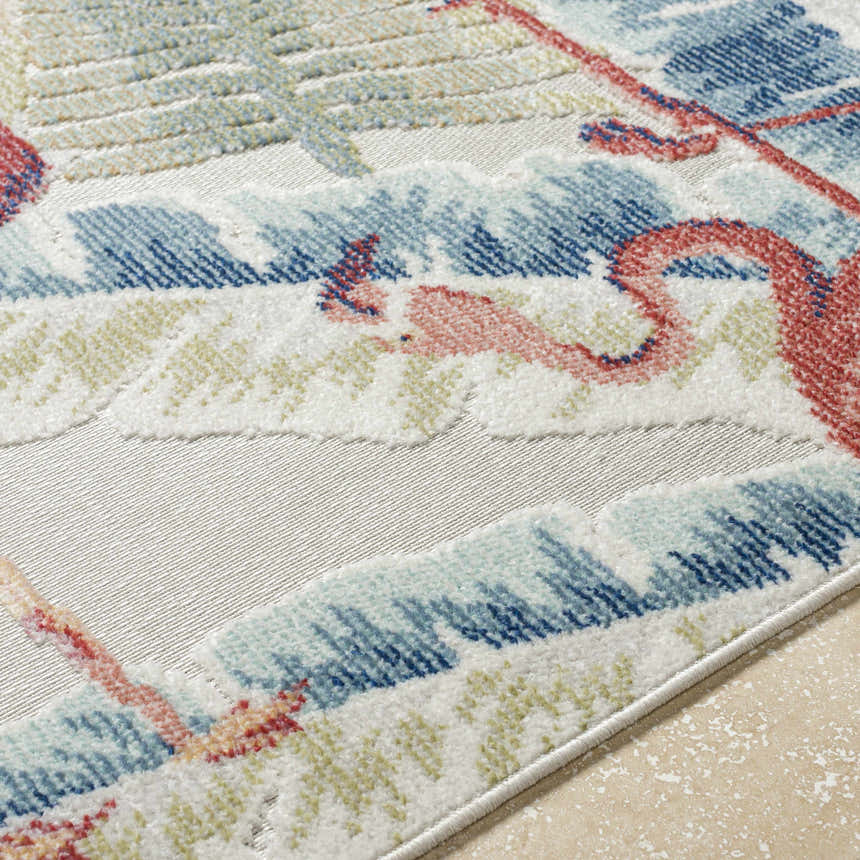 Close up of Nayan Light Slate Area Rug, showcasing flamingo, palm tree, and wave design in blue, cream, rust, and olive. Texture