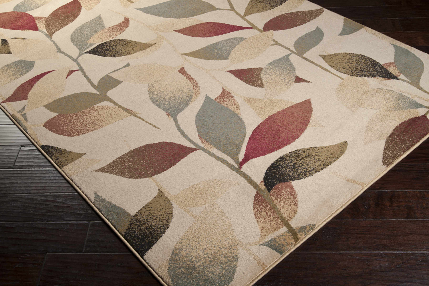 Close up of the Ober Fall Leaves Rug featuring a contemporary leaf pattern in red, brown, green, and black. Corner
