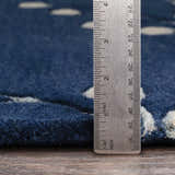 Close up of the ink blue Elsu Area Rug showing wool texture and pile height with a ruler for scale. Pile