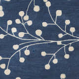 Close up of Blue Elsu Area Rug showing ink blue wool and a botanical design in tan. Swatch