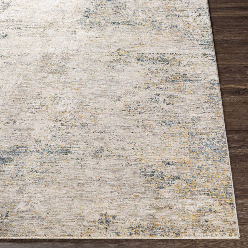 Close-up of the Odell Abstract Luxe Fringe Rug. Features dark blue, light blue, gray, and mustard colors. Front