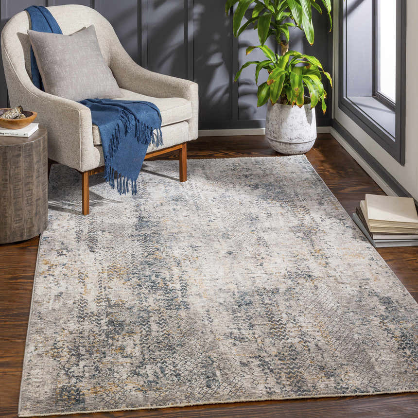 Living room scene with the Odell Abstract Luxe Fringe Rug in dark blue, gray, and mustard colors. Roomscene-Rectangle